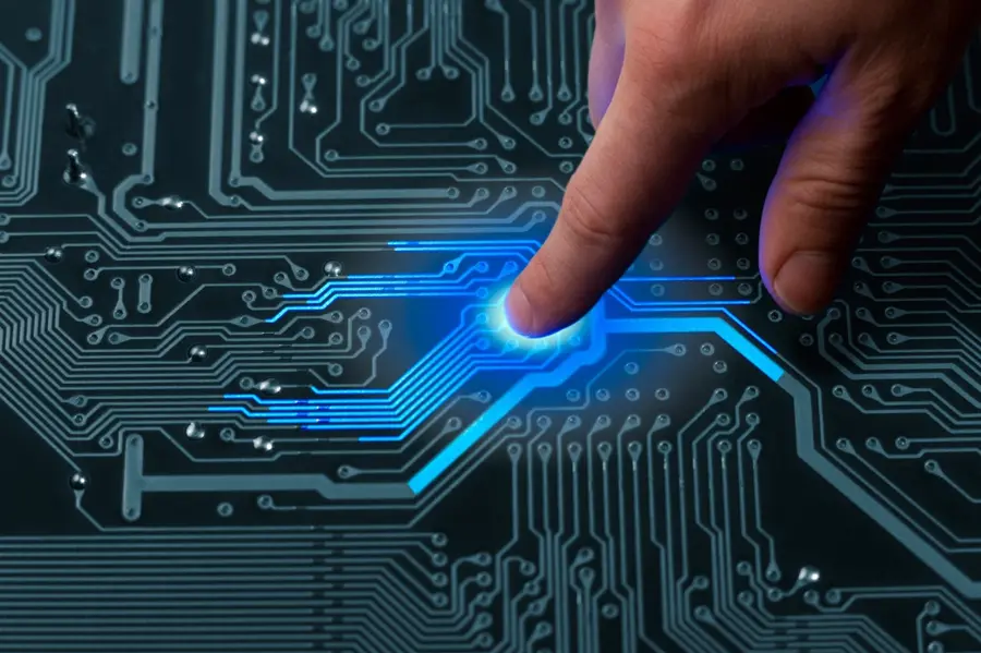A hand connecting with the circuits of a computer board